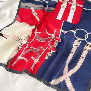 Detail of silk-like square scarf featuring horse bit patterns and elegant chain design