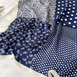 Détail du foulard en soie bleu marine à motifs paisley et pois avec bordures