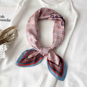Gros plan d'un foulard en soie rose à motif cachemire avec bordures bleues contrastées