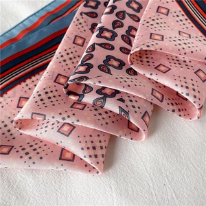 Vue détaillée d'un foulard en soie à motif paisley et pois roses avec éclat satiné