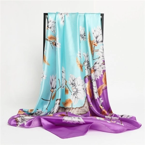 Detail of silk-like satin scarf featuring blue and purple floral print on black metal stand