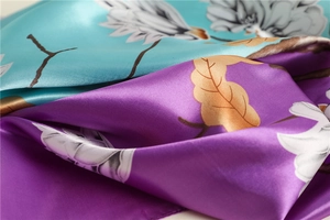 Macro detail of glossy satin silk scarf with blue and purple floral print pattern