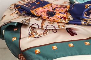Detailed macro view of silk scarf fabric showing glossy texture and vintage key pattern
