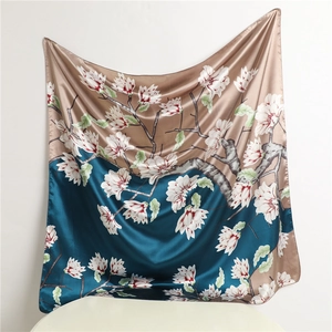 Detail of two-tone satin scarf featuring white magnolia print and glossy silk texture