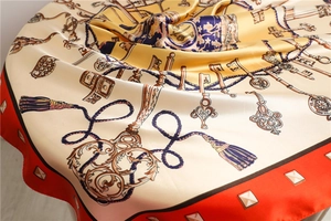 Detail of silk-like satin square scarf with vintage key patterns and tassel designs