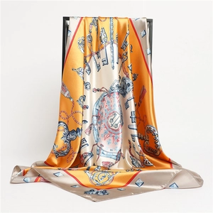 Detailed macro view of high-quality square silk scarf with vintage key and emblem patterns
