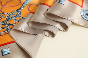 Close-up of luxury silk scarf showing vintage patterns and hand-rolled edge detail