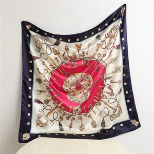 Close-up of luxury silk scarf with vintage key and tassel patterns in navy and red