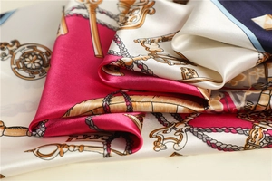 Macro detail of silk-like scarf featuring vintage gold key patterns and baroque rope texture
