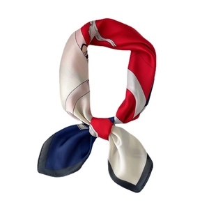 Fashionable tricolor silk scarf with red blue and beige patchwork design in a central knot
