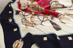 Macro detail of satin scarf with vintage key patterns and elegant tassel print