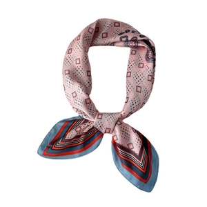 Carré de soie rose avec motifs géométriques à pois et paisley noué avec élégance