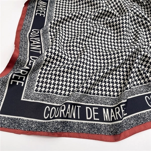 Dettaglio foulard in seta pied-de-poule con bordi blu navy e raffinate cuciture rosse