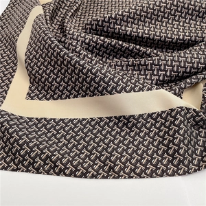 Detailed macro view of the textured twill silk scarf with brown monogram pattern