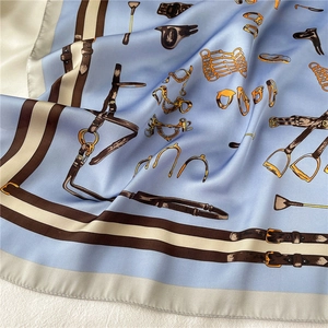 Macro detail of sky blue equestrian silk scarf with satin finish and classic horse motifs