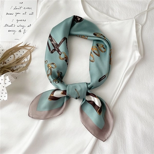 Detail of silk-like square scarf with horse bridle pattern on white satin dress