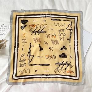 Detailed flat lay of equestrian pattern silk scarf with saddle and bit print motifs