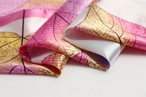 Close-up of pink and yellow gradient silk scarf with detailed leaf vein texture patterns