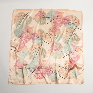 Detailed view of square silk scarf with elegant pink and green gradient leaf patterns