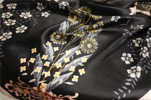 Detailed view of black satin scarf with sunflower and vintage floral print patterns