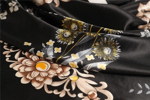 Macro shot of black satin silk scarf with sunflower print showing smooth texture and sheen