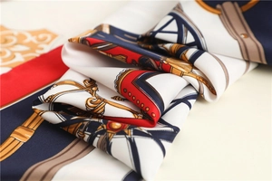 Close-up of luxury twill silk scarf showing intricate carriage patterns and texture