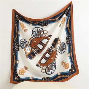 Detailed view of luxury silk scarf showing horse carriage patterns and royal crest emblems
