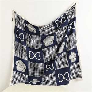 Dettaglio del foulard di seta blu e bianco con pied-de-poule, camelie e motivi a cuore