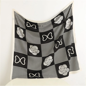 Elegante sciarpa in seta con motivi pied de poule nero bianco e fiori di camelia