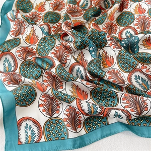 Foulard en soie avec motifs de feuilles à pois orange et bleu, vue drapée élégante