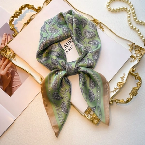 Élégant foulard en soie à motif Paisley vert sauge sur un plateau doré avec perles