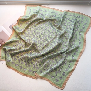 Gros plan détaillé d'un foulard en soie vintage avec motifs paisley vert menthe