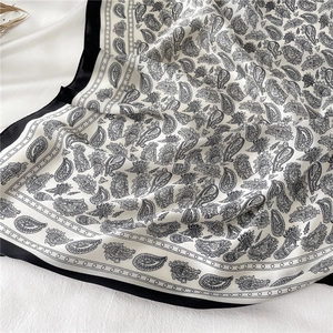 Gros plan du foulard en soie à motif cachemire noir et blanc avec texture brillante