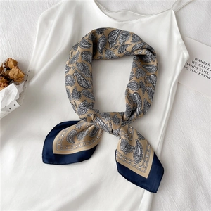 Foulard en soie champagne à motif paisley et bordure bleu marine sur robe blanche