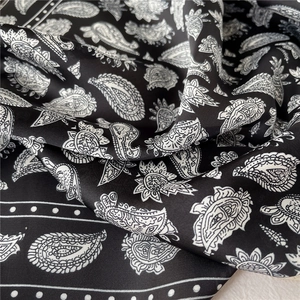 Détail du foulard en soie noire lisse avec des motifs cachemire vintage élégants