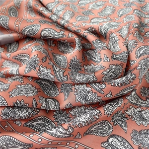 Gros plan d'un foulard en soie rose Morandi avec motif cachemire vintage et texture douce