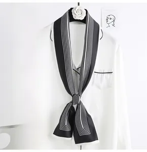 Gros plan d'un foulard étroit à rayures noué en nœud sur un col de chemise blanche