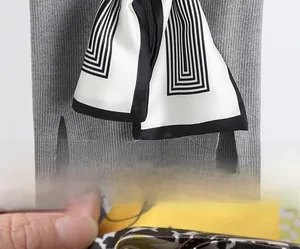 Détail de la couture intérieure invisible de qualité sur un foulard fin en soie rayée