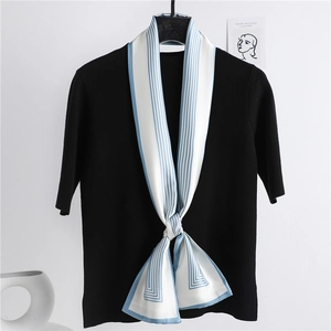 Écharpe fine en soie à rayures bleues et blanches sur tricot noir pour un look chic français