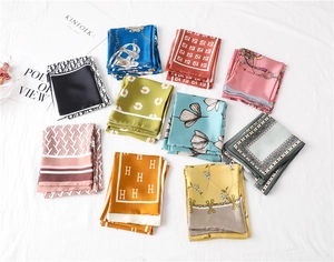 Close-up of silk texture scarves with floral and designer patterns on white fabric