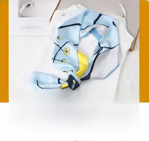 Detail of light blue floral silk scarf tied in a bow over white camisole top