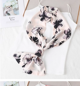 Detail of elegant pink floral silk scarf tied over white top with black flower print