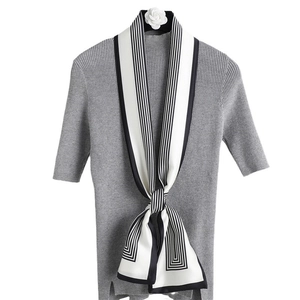 Écharpe étroite en soie à rayures noires et blanches avec un haut en tricot gris à manches