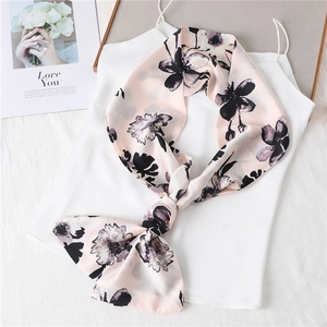 Detail of elegant floral print scarf tied in a knot on a white silk top fabric