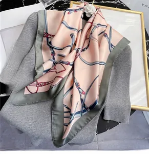 Detail of 70x70cm imitation silk square scarf with classic belt print on a knit sweater