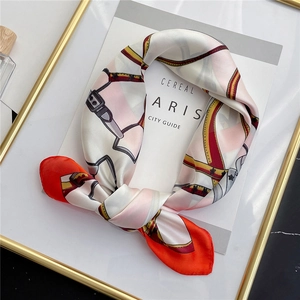 Detail of silk square scarf with equestrian belt buckle pattern and satin finish texture