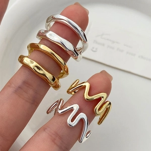 Close-up of irregular liquid metal and wavy minimalist ring set on finger