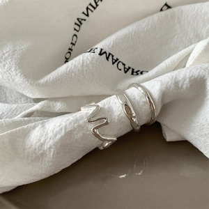 Three-piece silver metal ring set featuring wavy and hand-hammered irregular textures