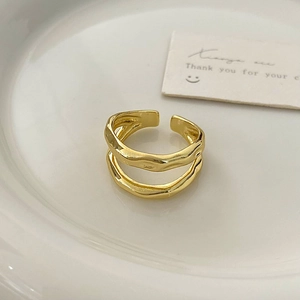 Detail of gold irregular double-layer wave ring with hand-hammered texture finish