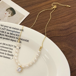 Detail of baroque pearl necklace showing the gold chain, zirconia pendant and clasp